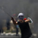 A Palestinian protester hurls a stone during clashes with Israeli forces