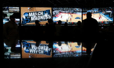 AP picture of people watching coverage of the first round of the NCAA college basketball tournament at the Westgate Superbook sports book in Las Vegas on March 15, 2018.