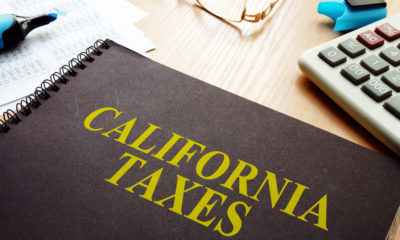 Picture of a ledger on a desk. The ledger is titled "California Taxes."