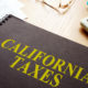 Picture of a ledger on a desk. The ledger is titled "California Taxes."