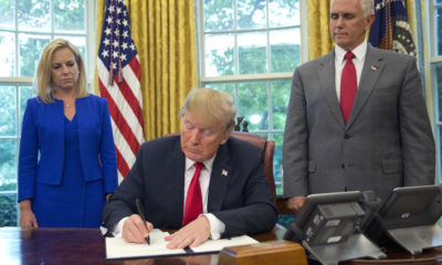 Photo of President Donald Trump signing order ending the separation of detained immigrant parents and children