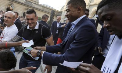 Photo of two French World Cup team members signing autographs