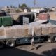 Photo of Palestinian worker next to cargo trucks