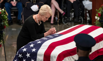 Photo of Cindy McCain leaning over John McCain's casket