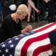 Photo of Cindy McCain leaning over John McCain's casket