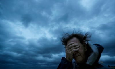 Photo of Russ Lewis covering his eyes from a gust of wind