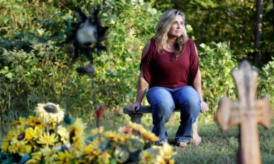 Photo of Heather Melton sitting by the grave of her late husband, Sonny Melton