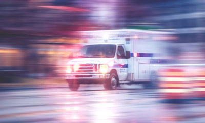 Photo of ambulance racing through city streets on a rainy night