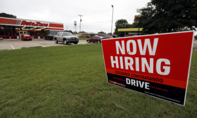 Photo of a "Now Hiring" sign in English and Spanish