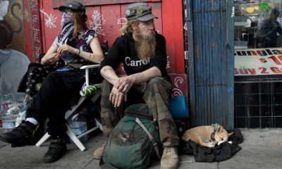 Photo of Stormy Nichole Day, Nord, and dog Hobo sitting on the street in San Francisco