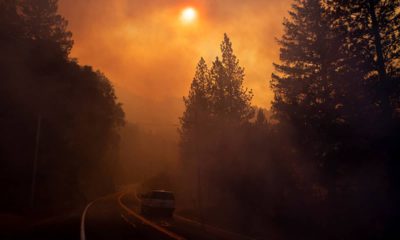 Photo of a car driving through smoke from a wildfire in Pulga, CA