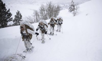 Photo of US Marines walking along a snow-covered trail