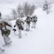 Photo of US Marines walking along a snow-covered trail