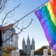 Photo of a woman holding a rainbow flag