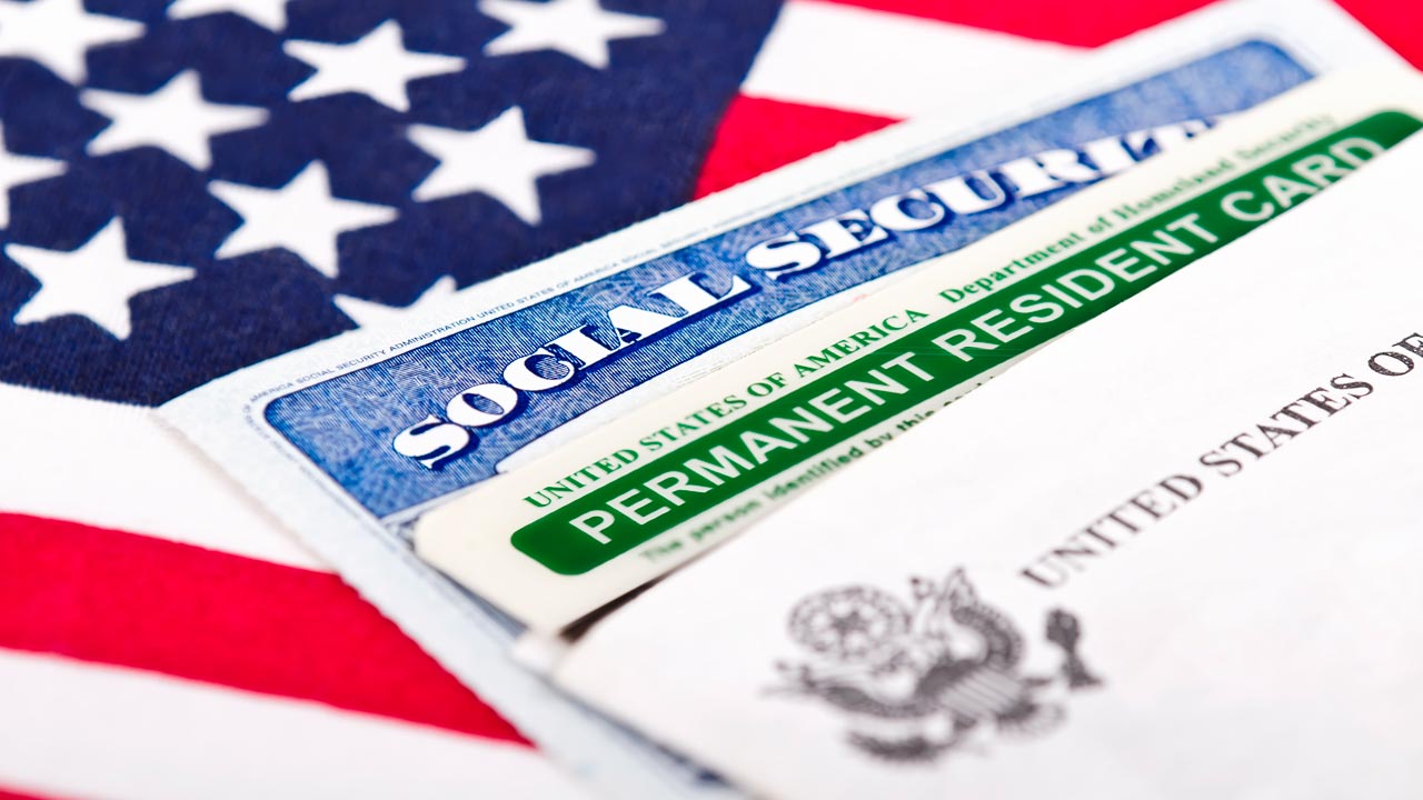 Composite of green card, social security card and American flag