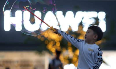 Photo of a child playing with bubbles near the Huawei logo