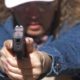 Photo of school secretary aiming a pistol at a shooting range