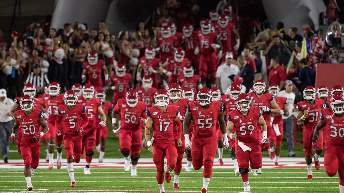 Photo of Fresno State football players running onto the field at Bulldog Stadium