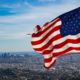 Photo of a flag waving with Los Angeles skyline in the background