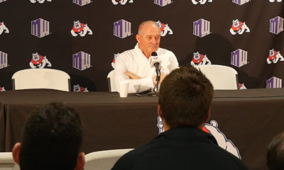 Photo of Jeff Tedford sitting at a table and talking to the media.