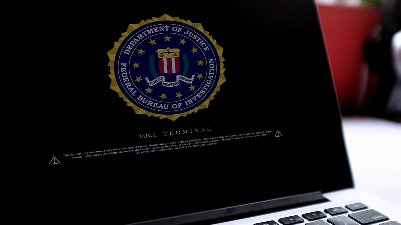 Photo of a laptop with a Department of Justice logo on the screens