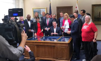 Photo of Gov. Gavin Newsom flanked by legislators and gun control advocates