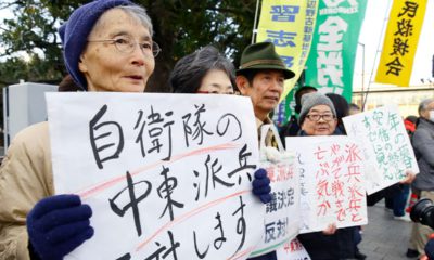 Photo of people holding placards protesting a troop dispatch tp the Middle East