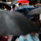 Photo of people sheltering under umbrellas in Australia