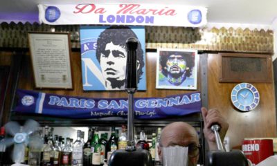 Photo of a bar tender preparing an espresso coffee inside the Bar Nilo where a makeshift shrine of soccer legend and former Napoli player Diego Armando Maradona is displayed