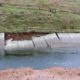 Photo of a canal with a damaged wall