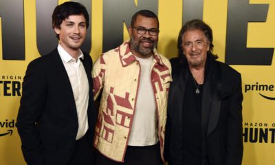 Photo of Jordan Peele, center, executive producer of the Amazon Prime Video series "Hunters," posing with cast members Logan Lerman, left, and Al Pacino