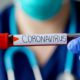 Photo of a physician holding a vial of blood marked coronavirus