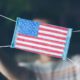 Photo of a man showing off a medical mask with an American flag on it