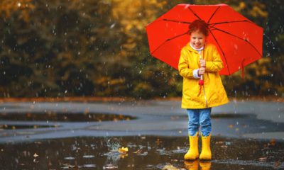 Picture of a young girl in yellow rain boots with a red umbrella