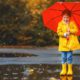 Picture of a young girl in yellow rain boots with a red umbrella