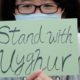 Photo of a man holding a sign during a rally to show support for Uighurs and their fight for human rights in Hong Kong