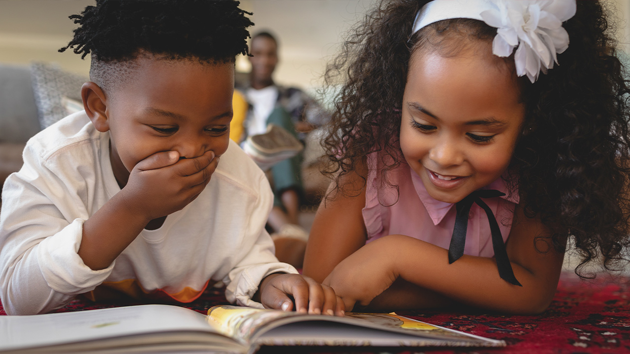 Image of two young African American students reading together