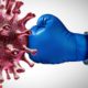 Image of a gloved hand landing a punch against the coronavirus