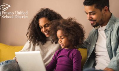 Image of Black parents checking out what their daughter is learning on her laptop