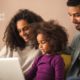 Image of Black parents checking out what their daughter is learning on her laptop