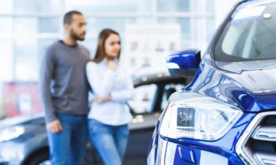 Photo of a man and woman shopping for a new car at a dealership