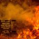 Photo of a sign for a senior center surrounded by wildfire flames