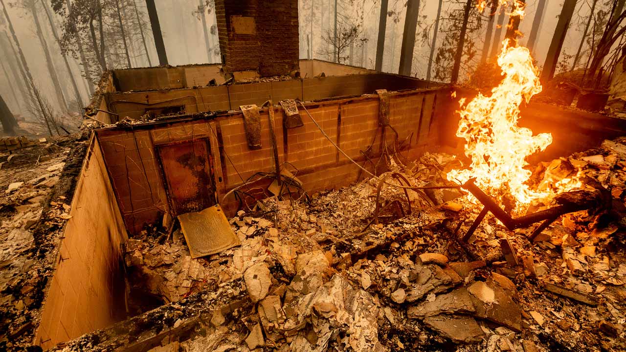 Flames burn at a home leveled by the Creek Fire along Highway 168 on Tuesday, Sept. 8, 2020, in Fresno County, Calif. (AP Photo/Noah Berger)