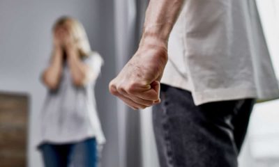 Photo of a man with a balled first near a woman symbolizing domestic violence